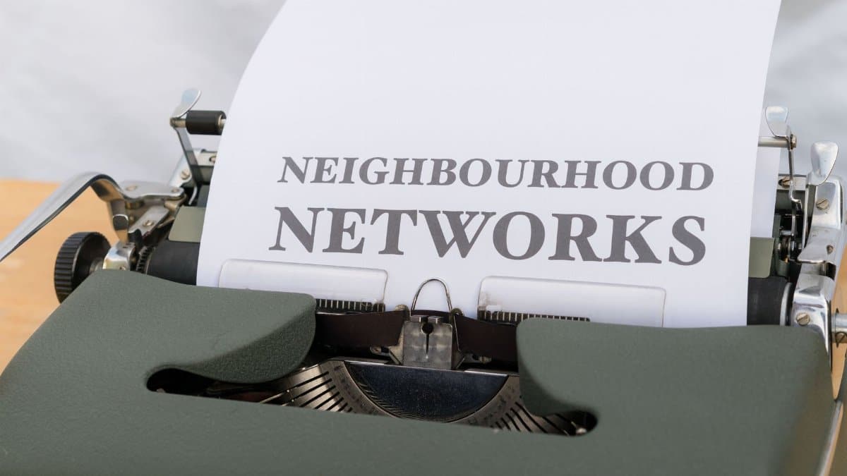 Close-up of a vintage typewriter with 'Neighbourhood Networks' text on paper.