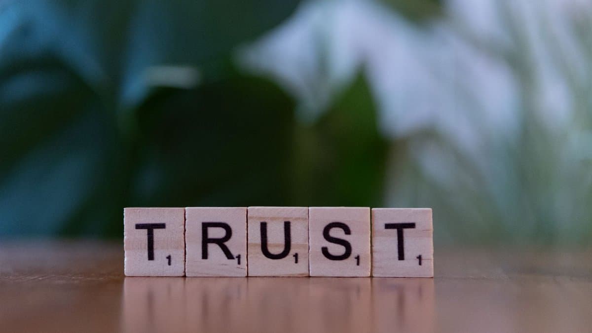 Wooden letter tiles spelling TRUST on a wooden surface, symbolizing integrity and values.