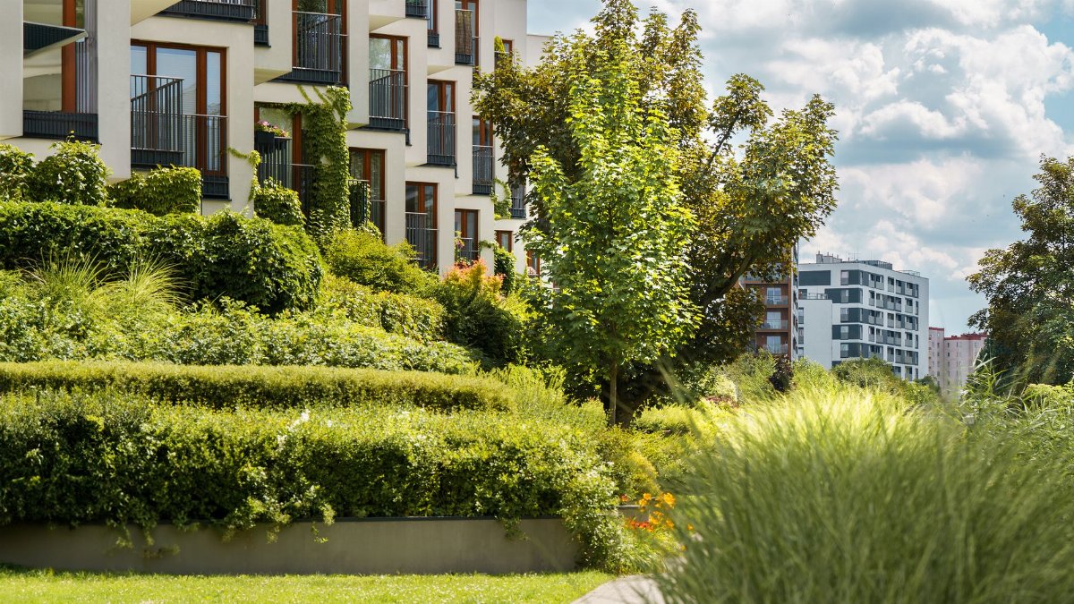 Elegant modern residential complex with lush gardens and urban landscape views.