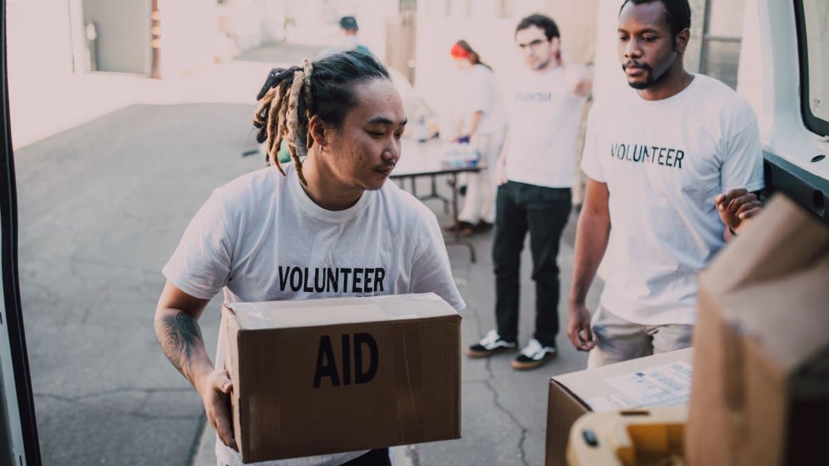 Volunteers unload aid supplies from a van, showcasing teamwork and community support.
