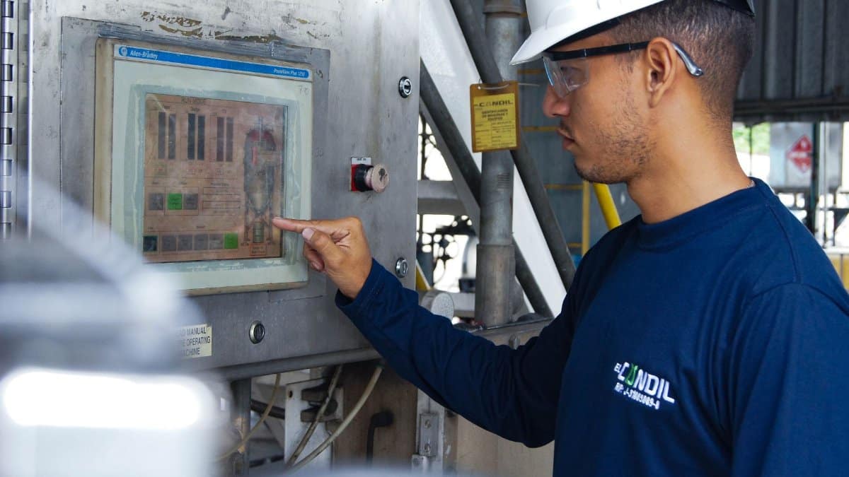 Engineer using control panel at industrial facility, ensuring operational efficiency.