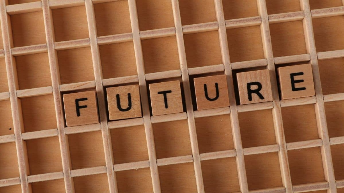 Wooden letter blocks spell 'FUTURE' on a wooden grid background.