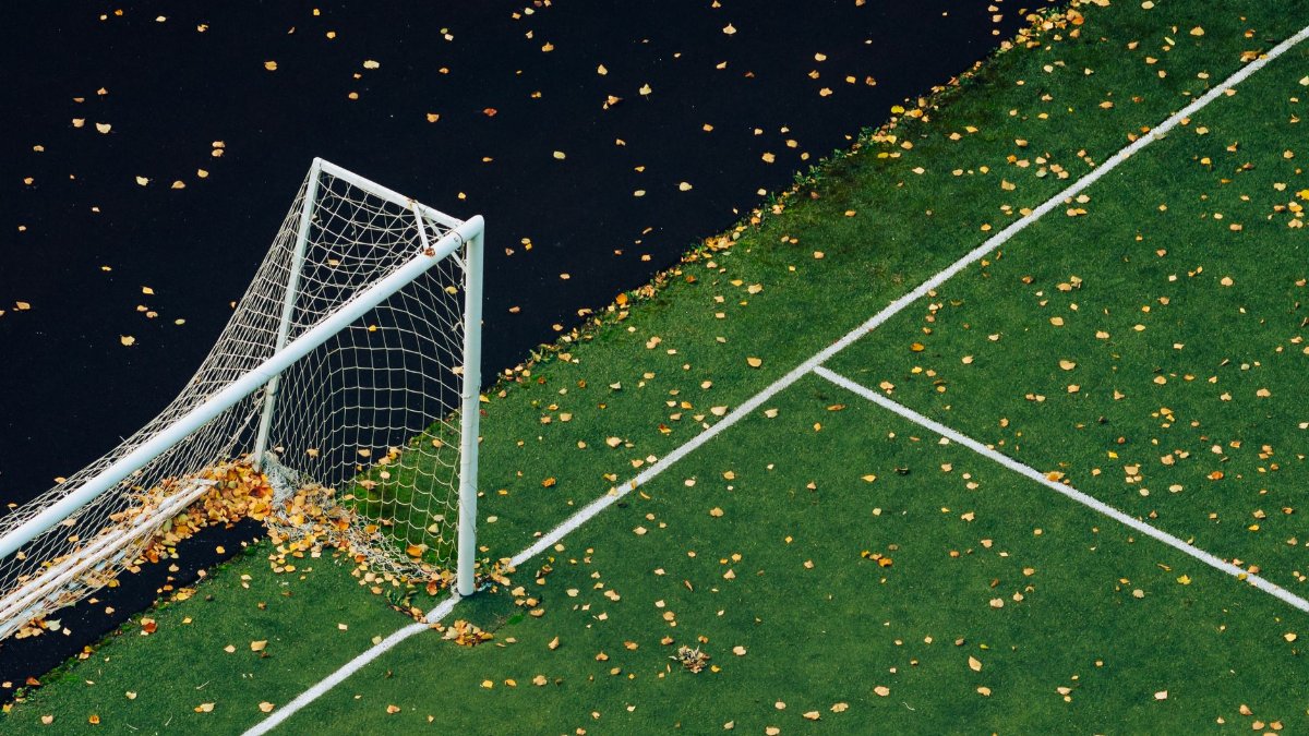Aerial view of soccer field with autumn leaves scattered across, capturing the essence of fall sports.
