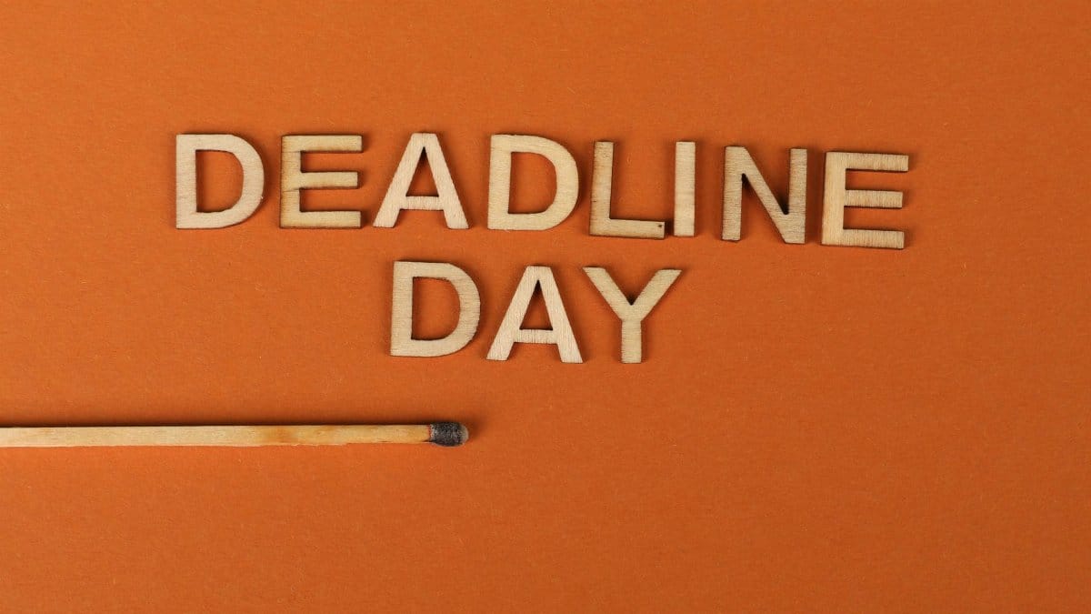 Conceptual image of a deadline with wooden letters and burnt matchstick on orange background.