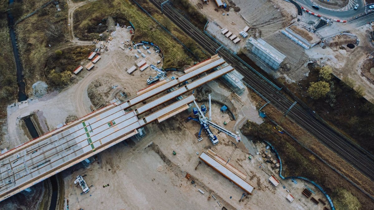 Aerial shot of an urban bridge construction site with machinery and infrastructure development.