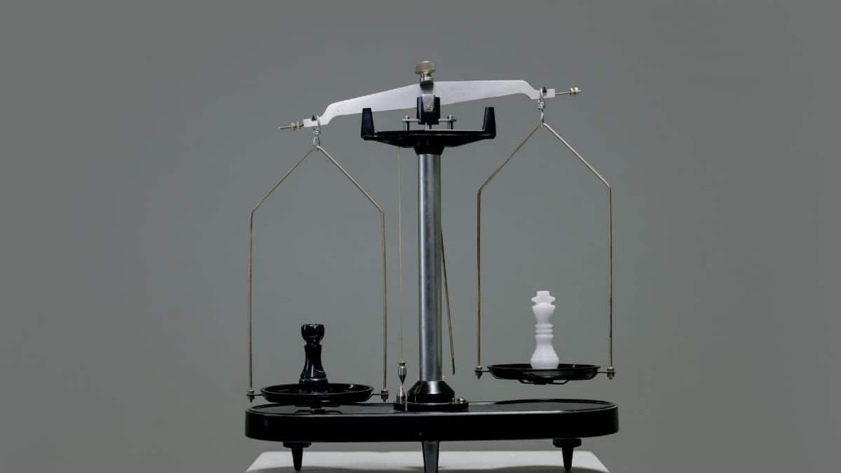 Chess pieces balanced on a scale depicting equality or strategy in decision making.