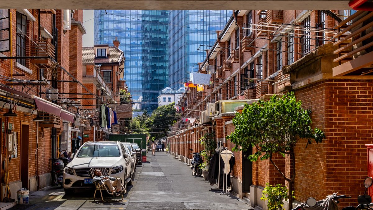 Vibrant city alleyway with red brick buildings and modern skyscrapers.