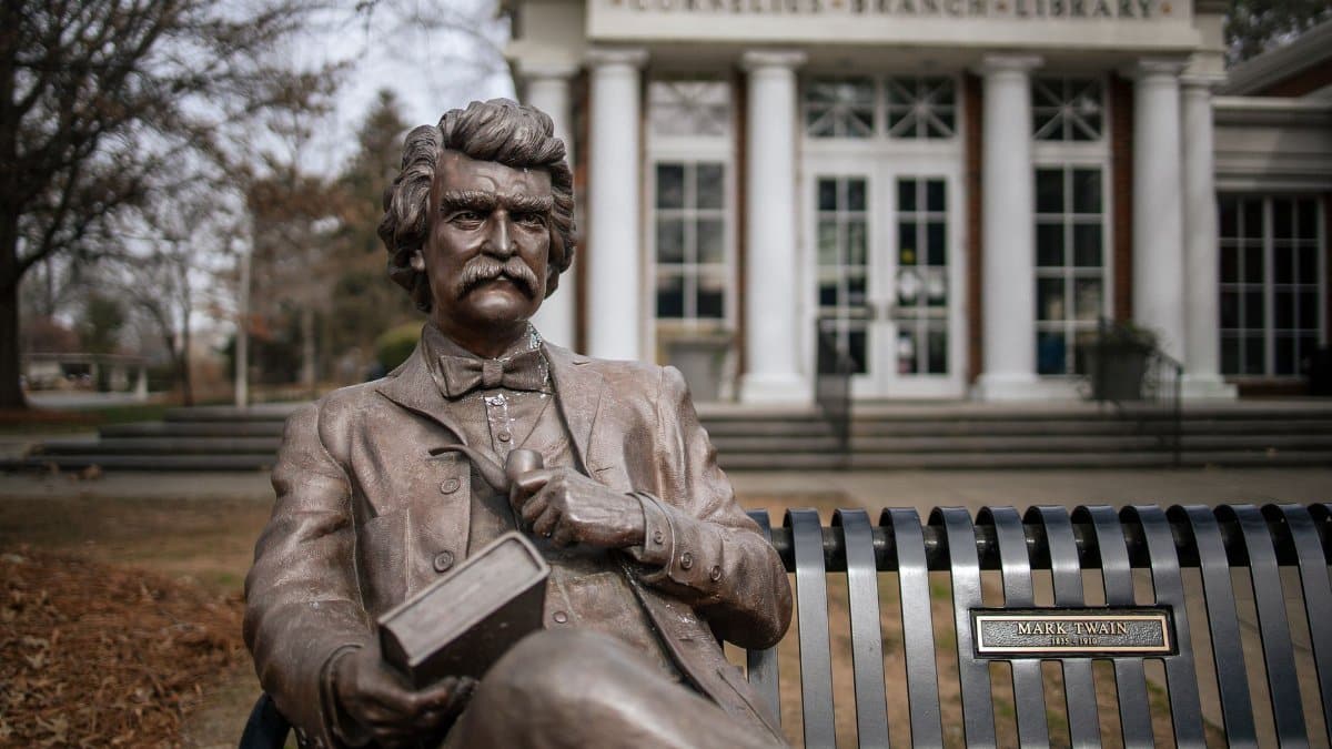 Bronze statue of Mark Twain outside Cornelius Branch Library. Prominent literary figure captured in art.