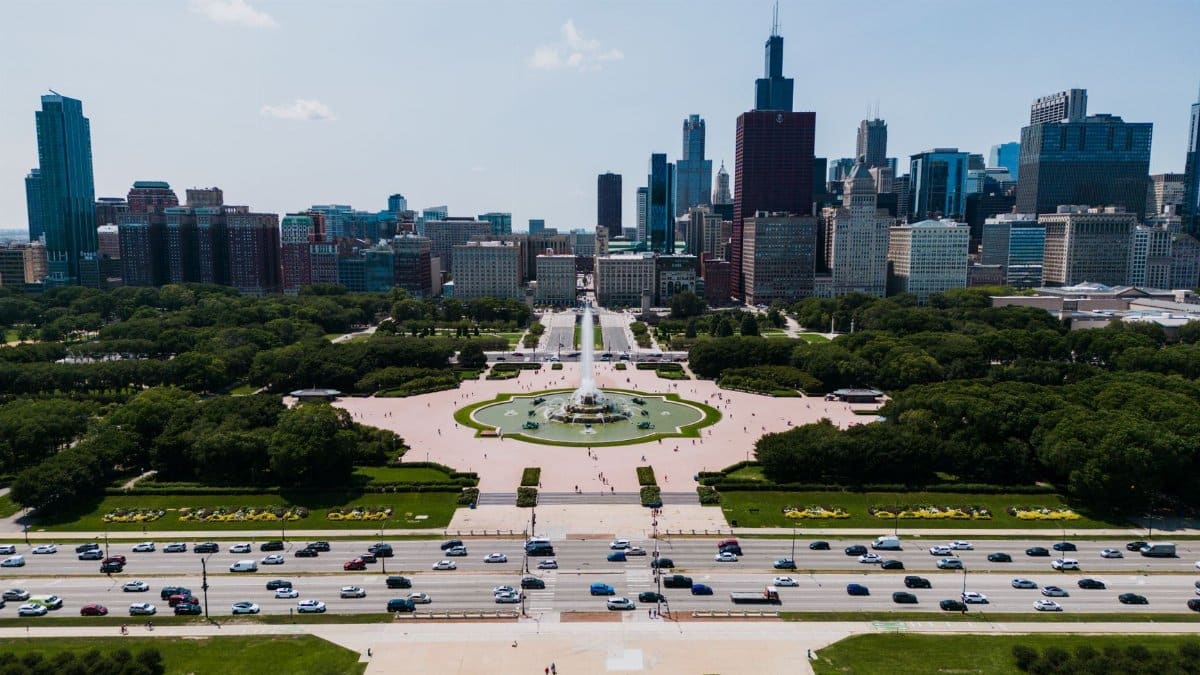 Aerial view of Buckingham Fountain with Chicago skyline in the background, vibrant summer day.