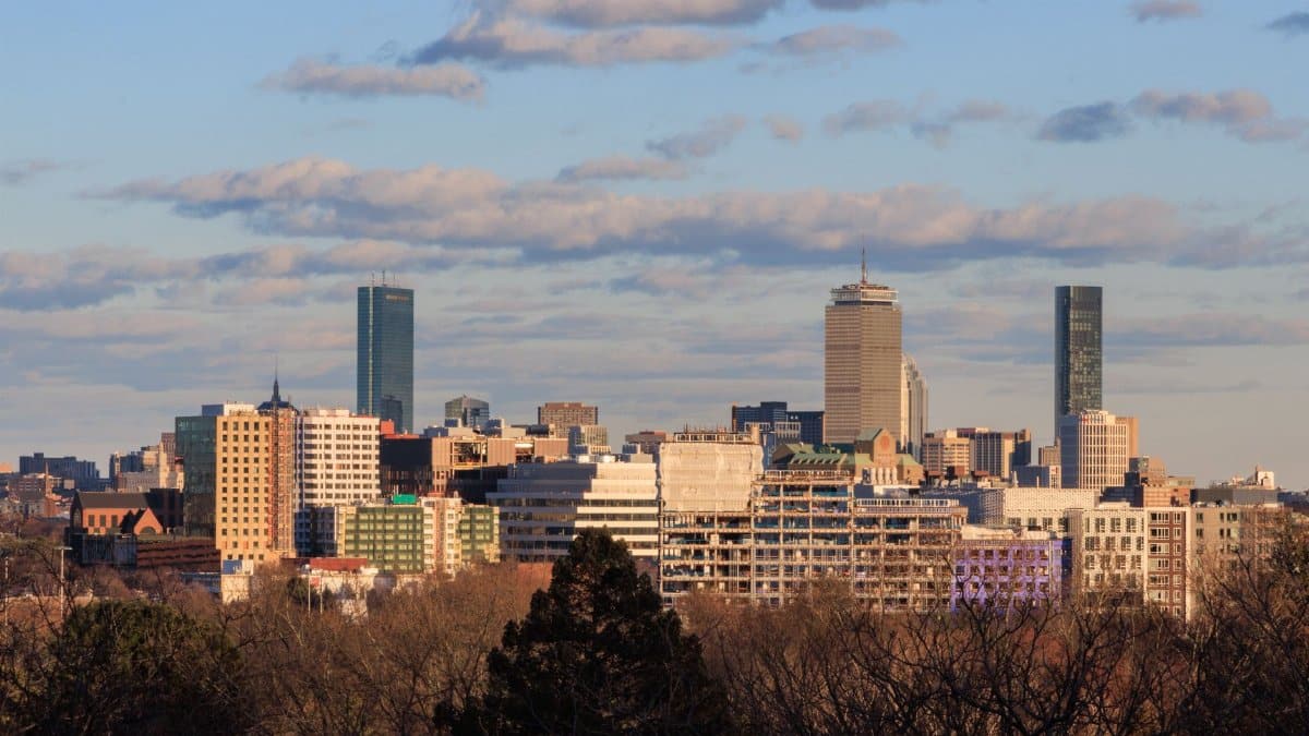 Skyline view of Cambridge, Massachusetts with Boston cityscape in the background under a clear sky.