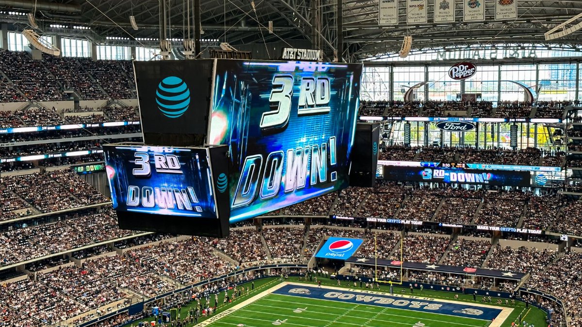 An exciting football game is underway at the AT&T Stadium in Arlington, Texas, with a packed crowd and dynamic atmosphere.