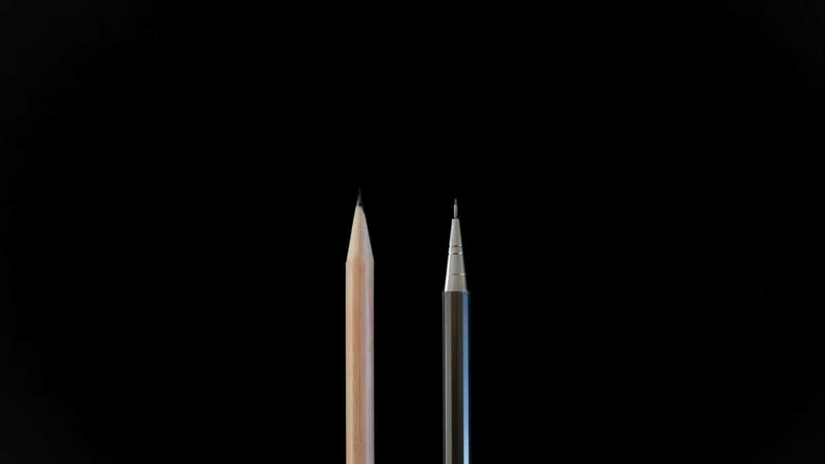 A clean, minimalist shot showcasing a traditional pencil and a mechanical pencil against a black background.