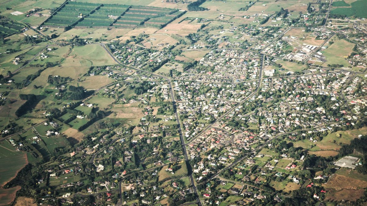 A picturesque aerial view showcasing a sprawling countryside landscape with fields and houses.