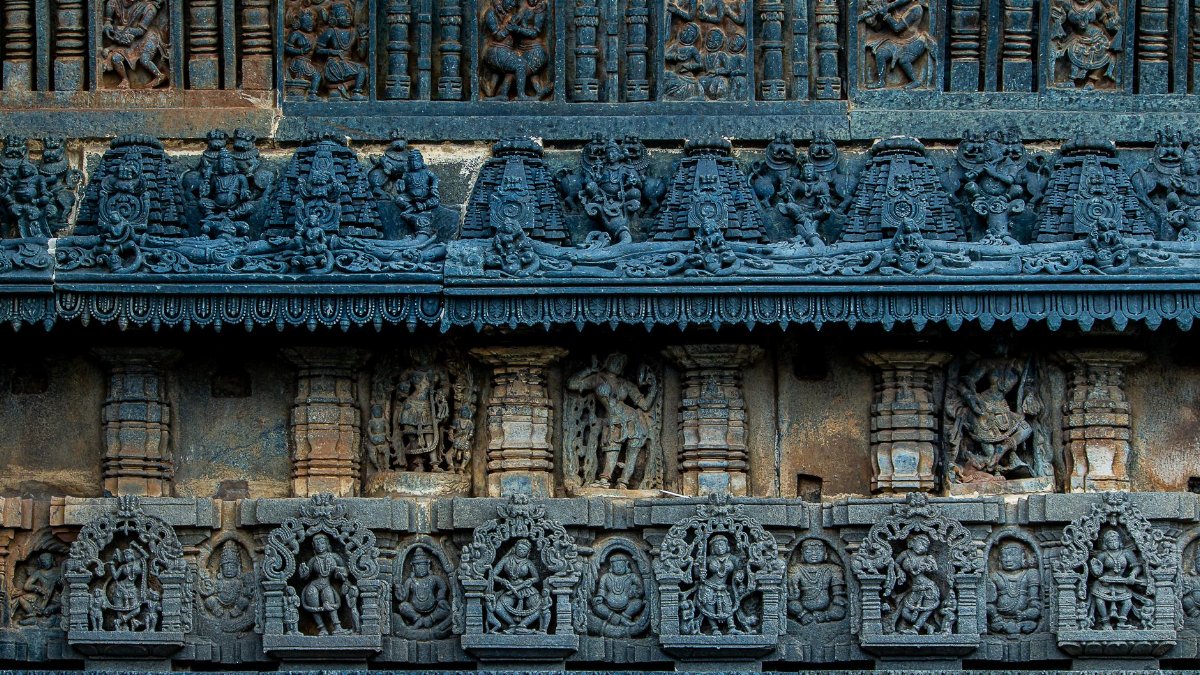 Detailed view of intricate stone carvings on a historic temple wall, showcasing ancient craftsmanship.