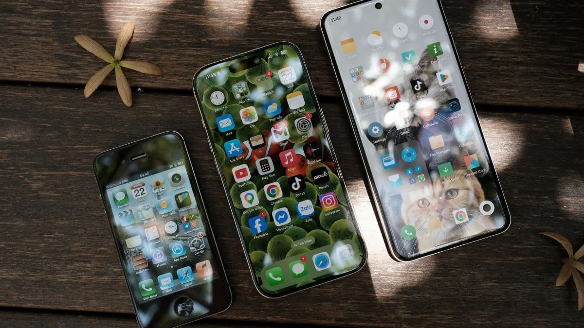 A collection of smartphones showing different app icons, placed on a wooden surface in natural light.