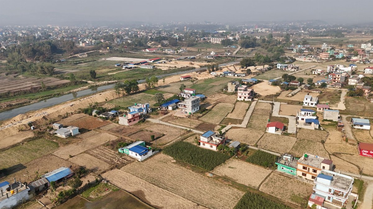 Aerial shot of a rural village in Nepal showcasing fields and scattered houses.