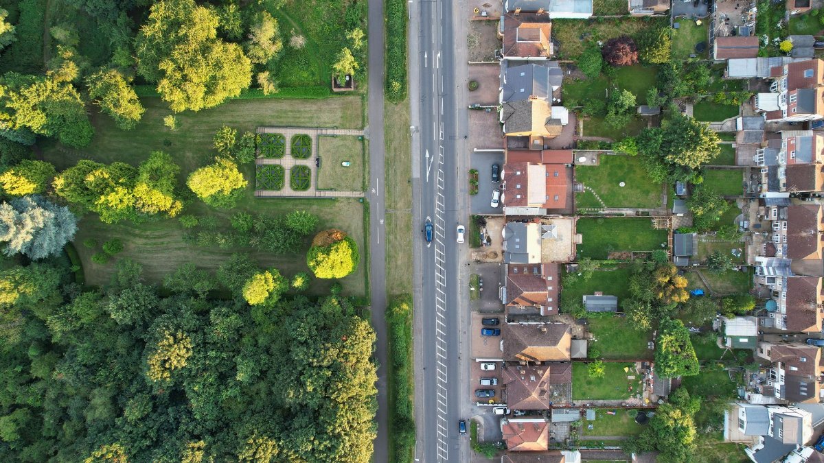 Drone view showcasing a residential area in Luton, England surrounded by lush greenery.