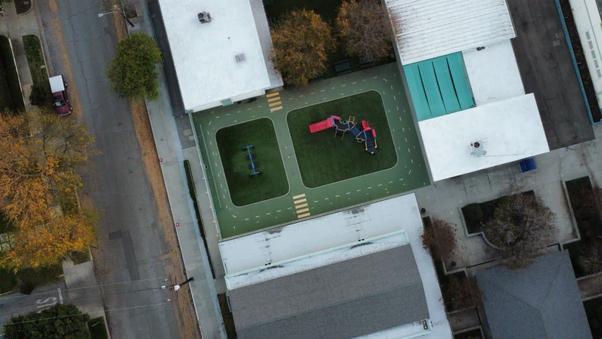 Top-down shot of a playground with colorful equipment in an urban city setting.