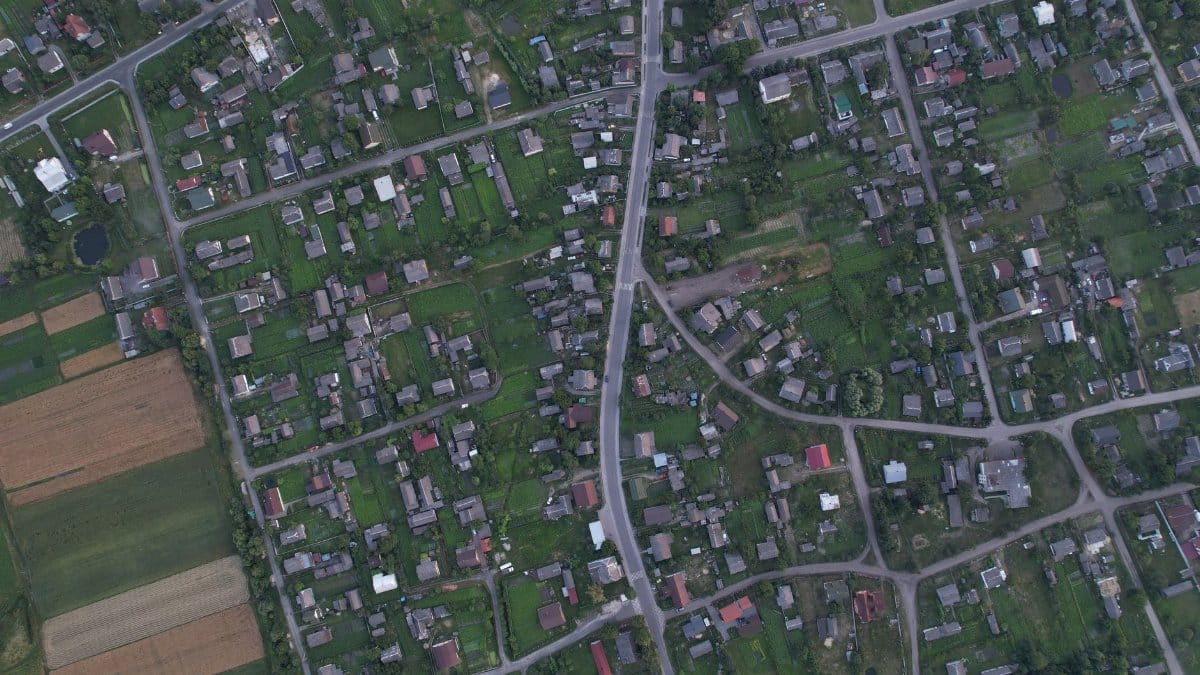 Aerial photo of a residential neighborhood in Shats'k, Ukraine, showcasing green spaces and homes.