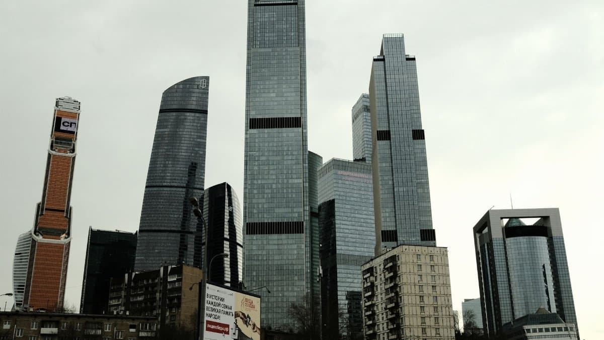 Glass skyscrapers in Moscow City, Russia, showcasing modern architecture against a cloudy sky.