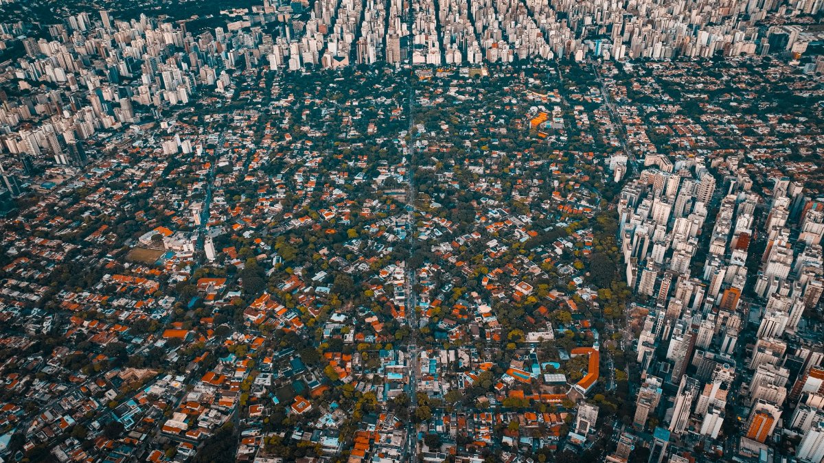 Stunning aerial photo showcasing the contrast between dense city skyscrapers and suburban houses.