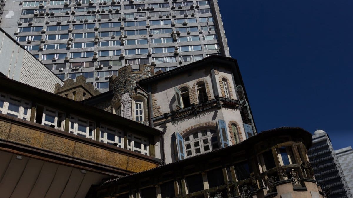 A low-angle view of mixed architectural styles featuring historic and modern urban buildings.