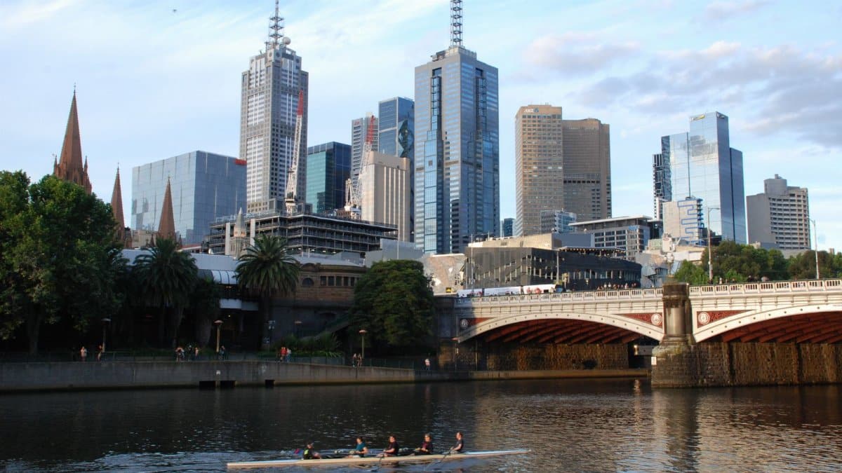 Modern skyline of Melbourne with rowers on the Yarra River, showcasing the city's blend of urban architecture and outdoor lifestyle.