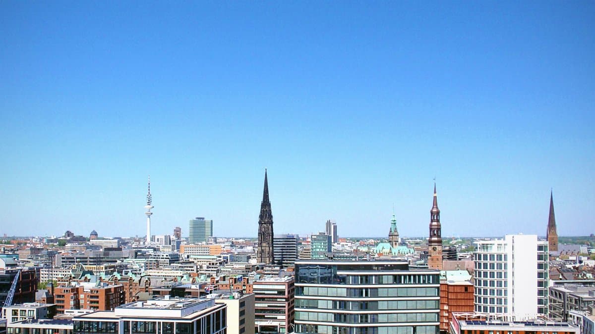 High-rise buildings under clear blue sky in Hamburg cityscape.