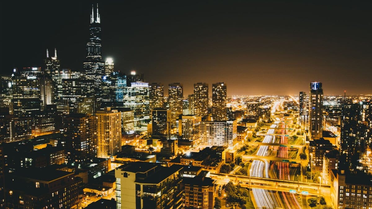 A breathtaking view of Chicago's illuminated skyline and busy highways at night.