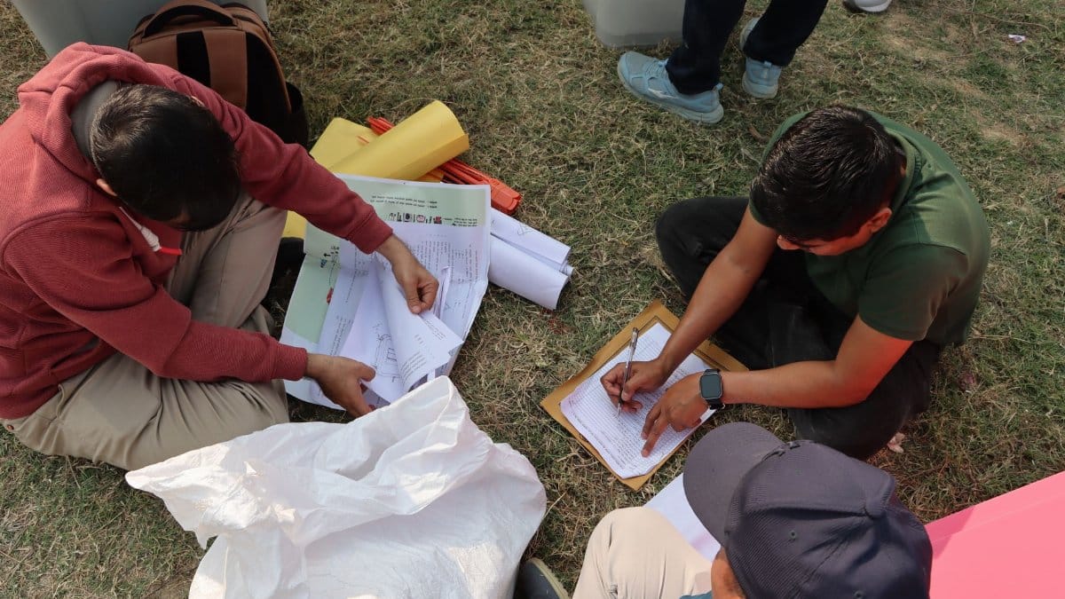 Election officials organizing ballots in an outdoor setting in Nepal, highlighting the electoral process.