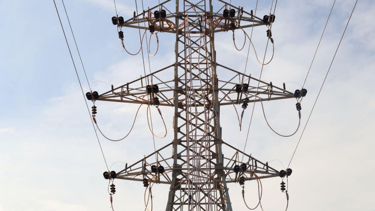 Steel transmission tower with power lines extending across the sky, showcasing modern infrastructure.