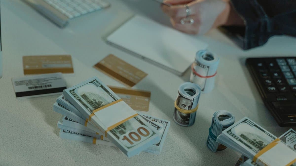 Close-up of dollar bills and credit cards on a desk, symbolizing financial transactions.
