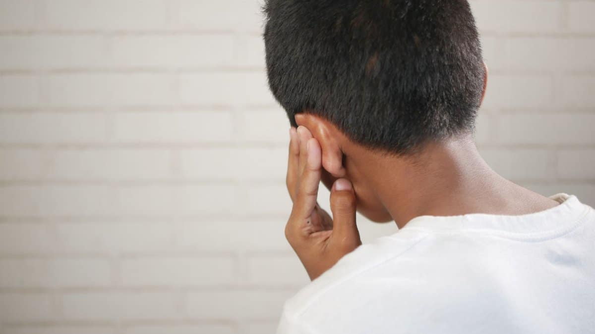A child is depicted covering their ear, suggesting discomfort or concern.