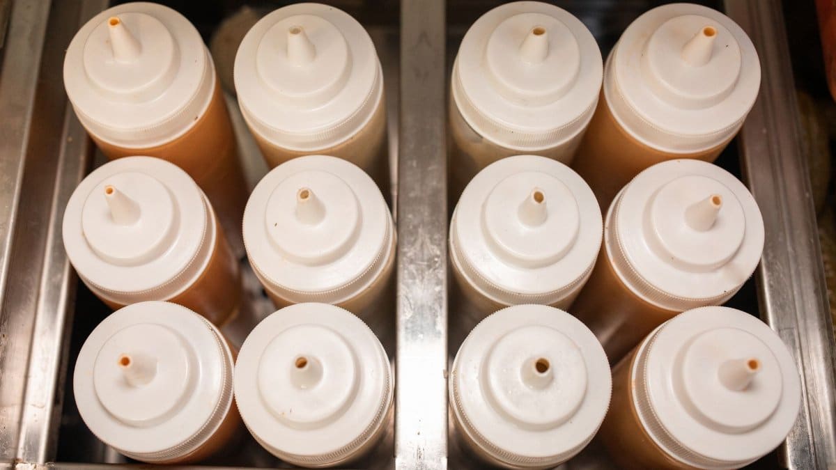 Top-down view of condiment bottles in a steel holder, perfect for kitchens.