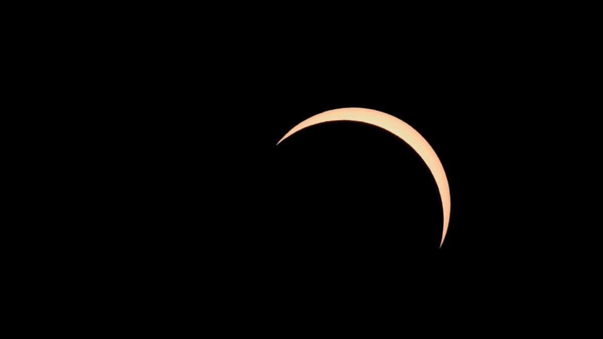 Partial solar eclipse capturing a crescent sun against a dark sky.