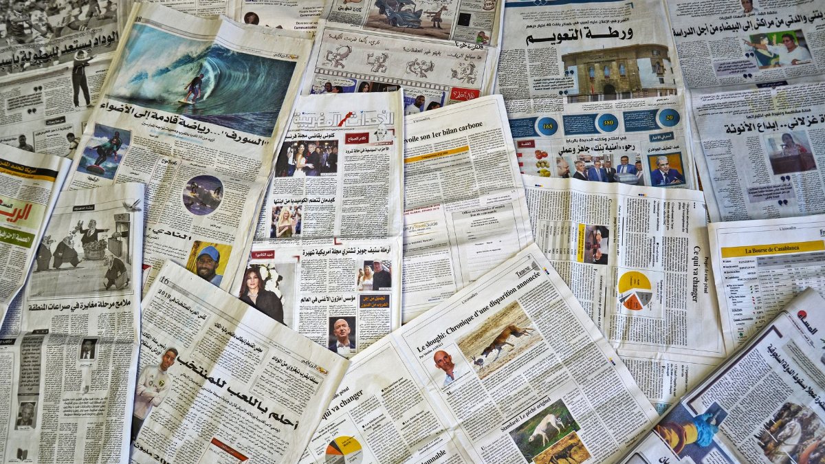 A variety of Arabic newspapers laid out, showcasing cultural and news diversity in Fès, Morocco.