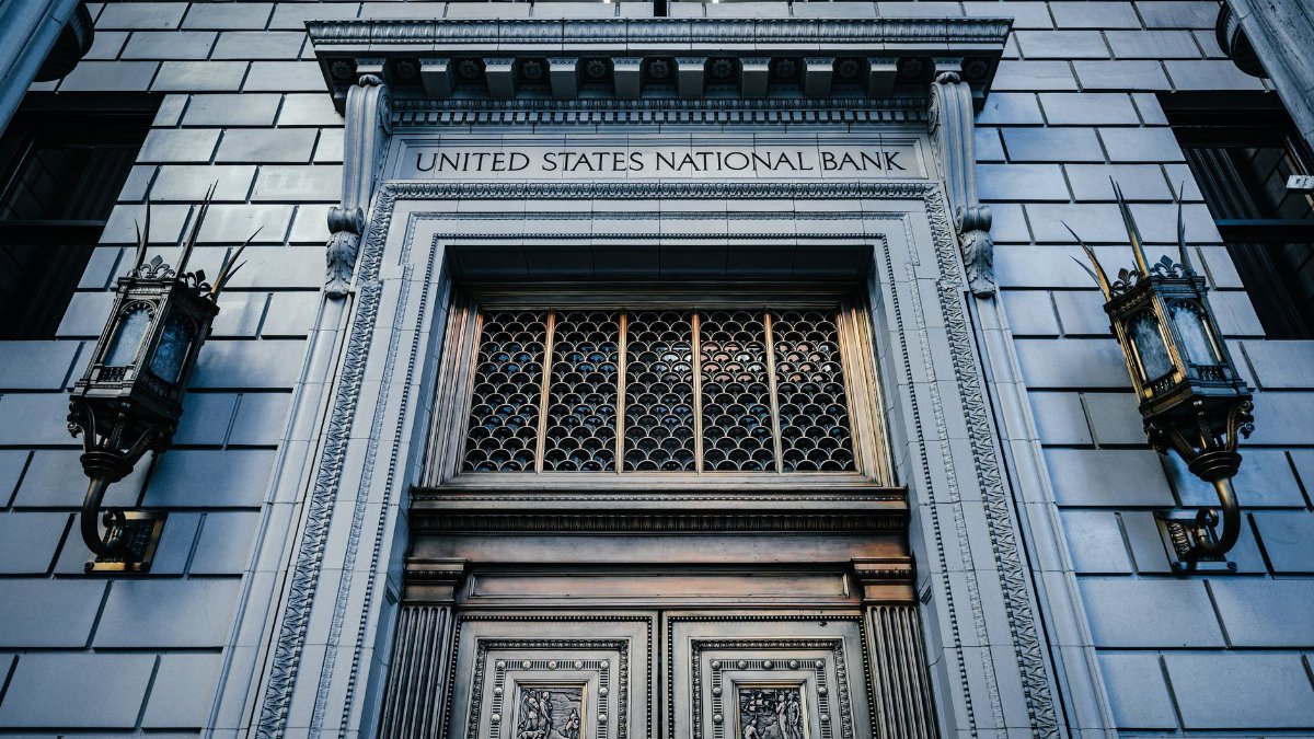 From below classic styled historic building of United States National Bank with wooden doors and vintage lanterns located in Portland