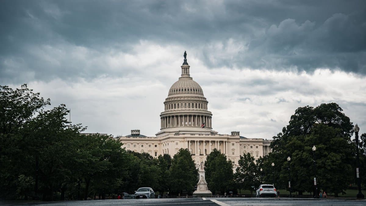 A dramatic view of the US Capitol under cloudy skies in Washington, DC.