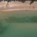 Drone captures sandy beach and clear water along the scenic Lake Michigan shoreline in Bliss, Michigan.
