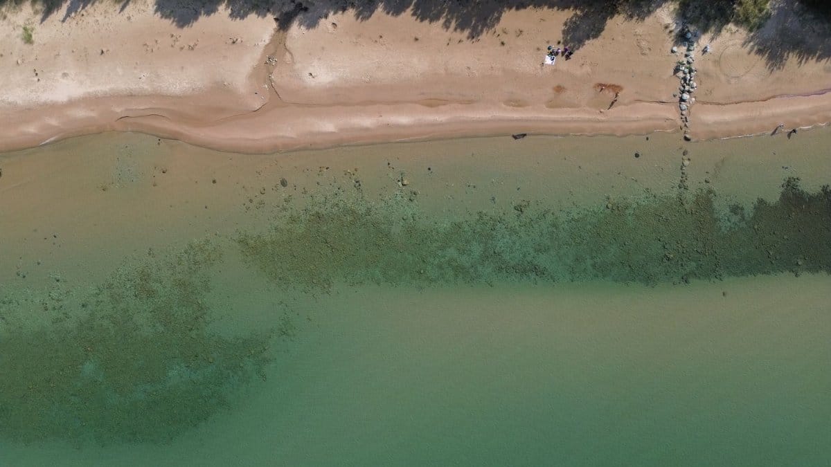 Drone captures sandy beach and clear water along the scenic Lake Michigan shoreline in Bliss, Michigan.