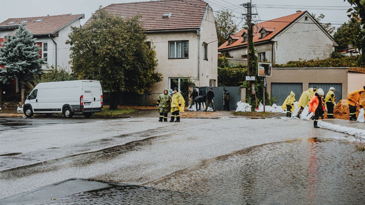Emergency response team tackles flooding in a residential neighborhood with sandbags and preparation.