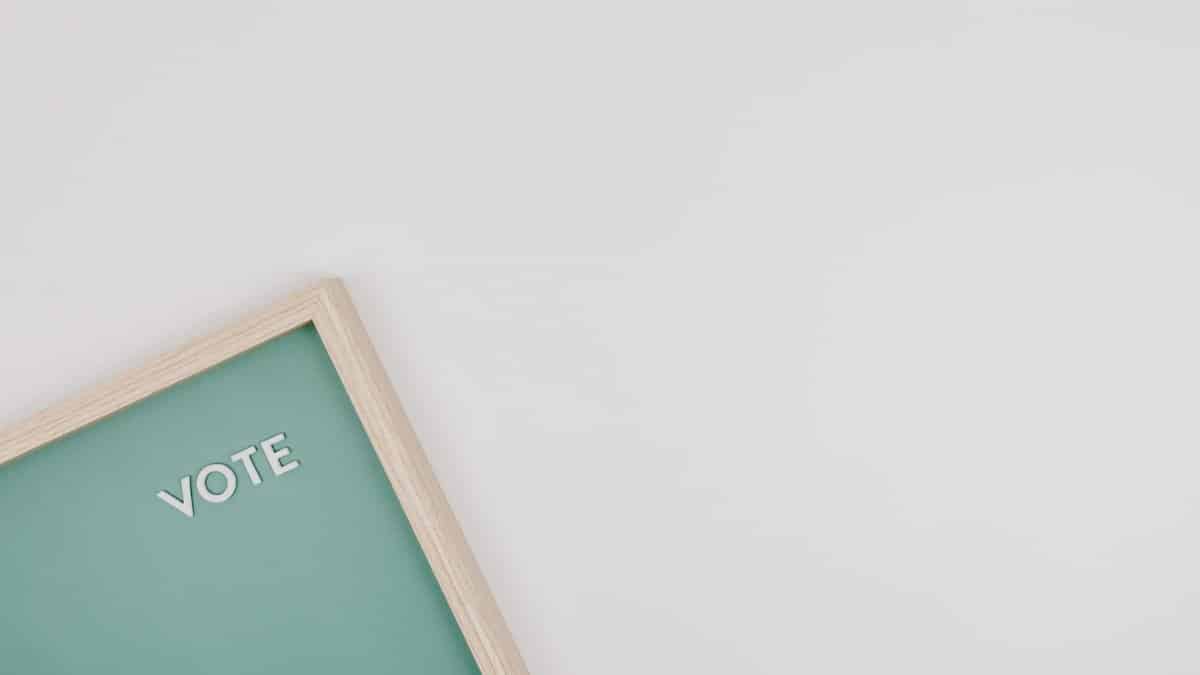 Minimalist letter board with VOTE text on a green background, perfect for election themes.