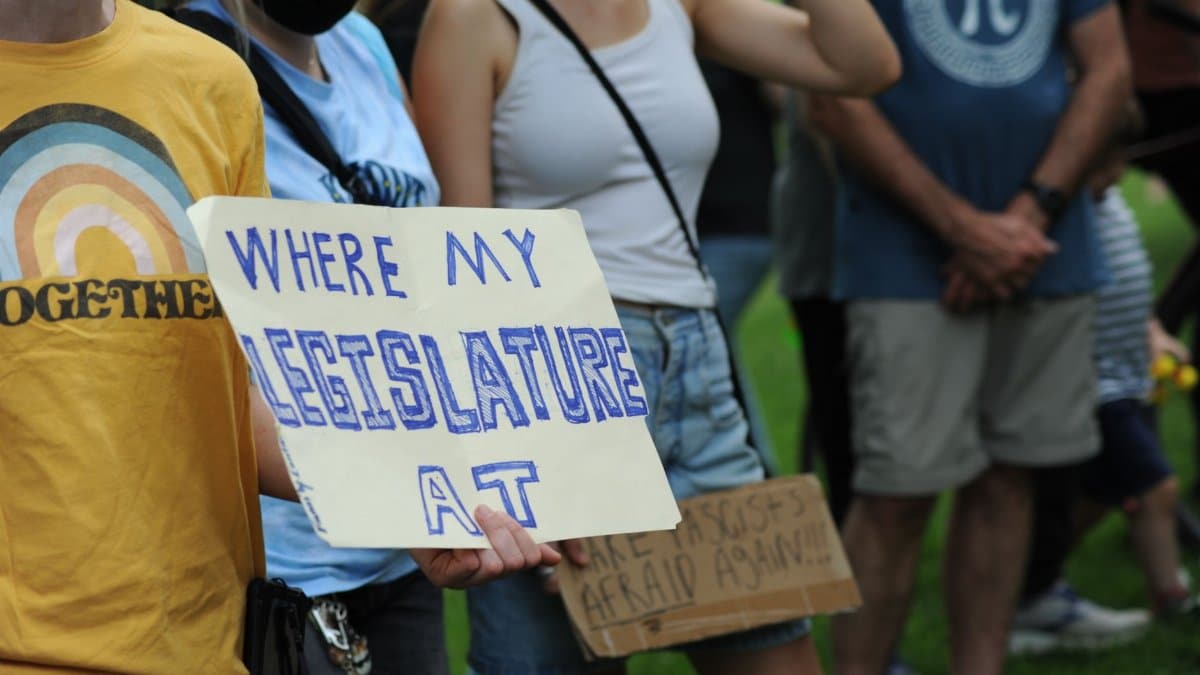 A group of people in Baltimore, Maryland, protesting with handmade signs advocating for legislative change.