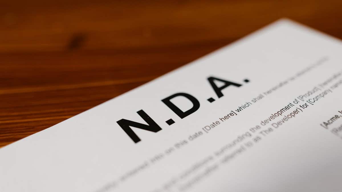 Focused close-up of an NDA document on a wooden desk, highlighting contract details.