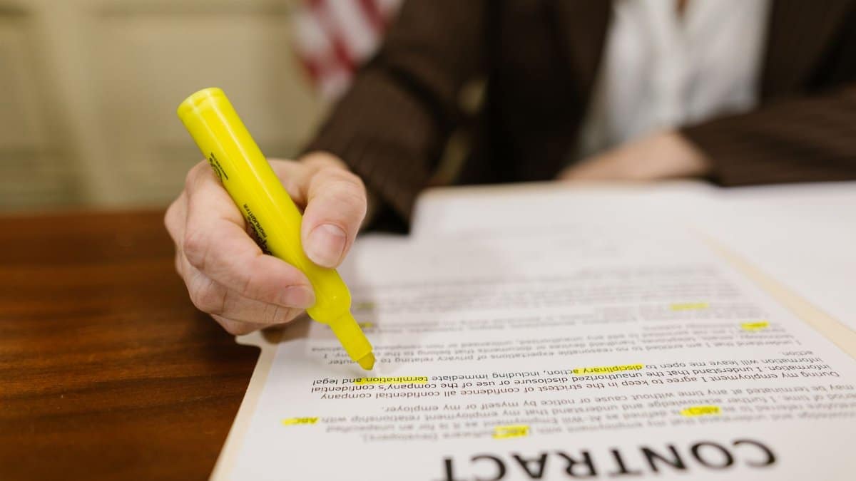 A close-up of a hand highlighting a contract, emphasizing important legal terms.