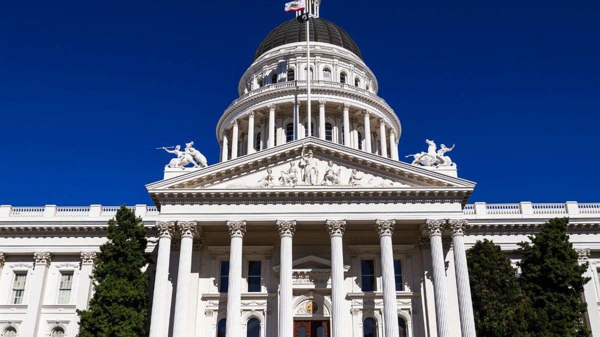 Sunlit view of the California State Capitol with clear blue skies.