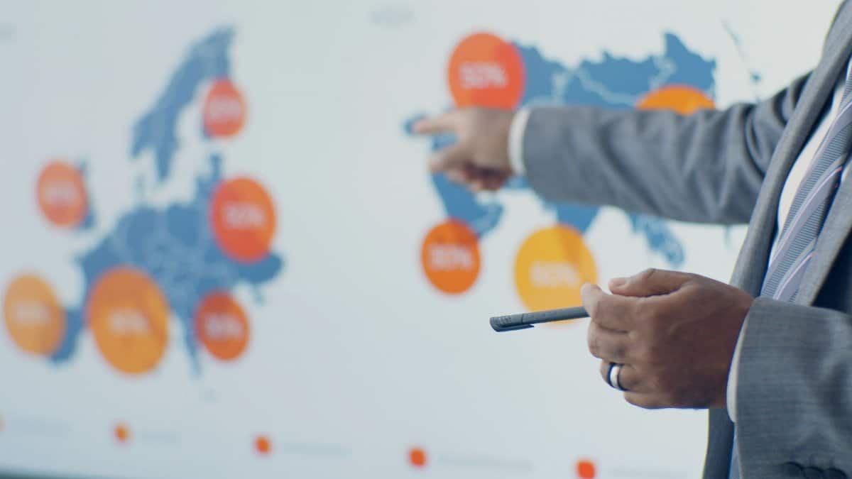 Professional presenting detailed analytics on European map during office meeting.