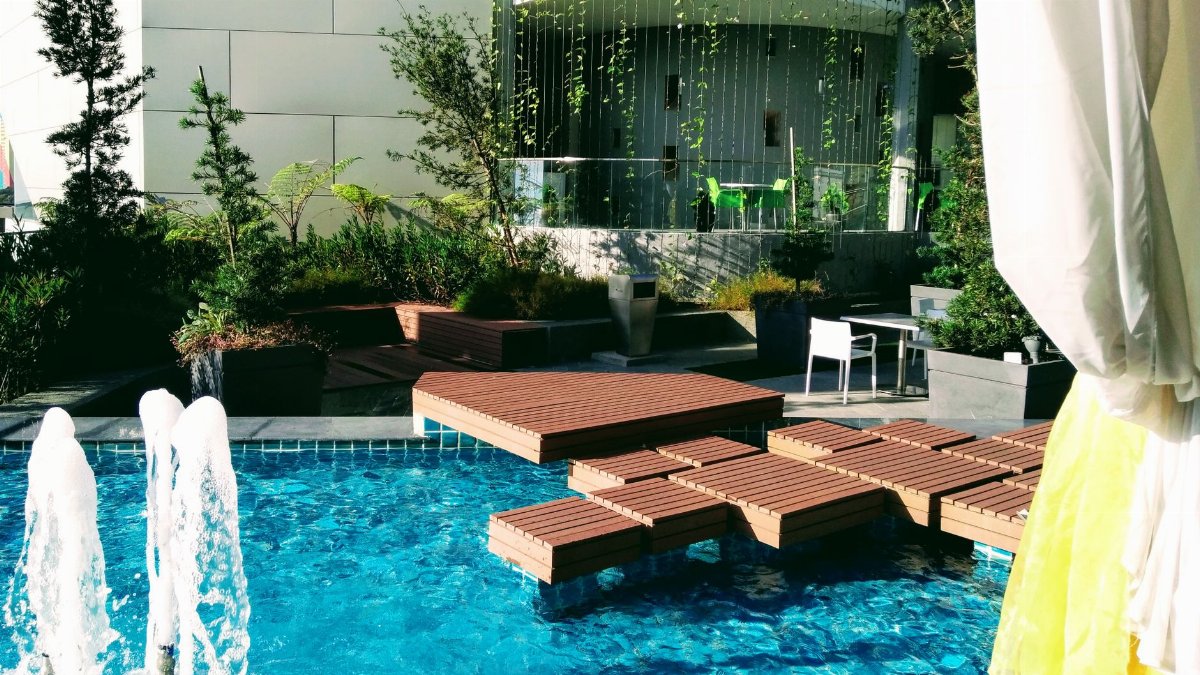 A luxurious outdoor pool area with stylish decking and a beautiful fountain, perfect for relaxation.
