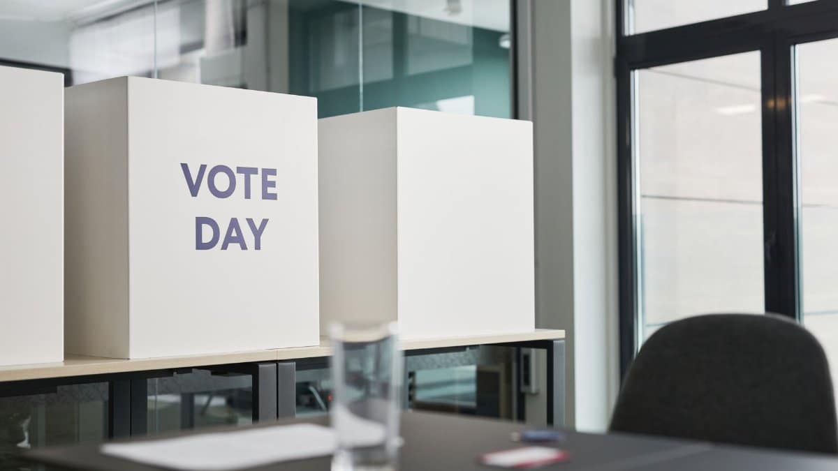 A modern office with voting booths labeled 'Vote Day' indicating election activity.