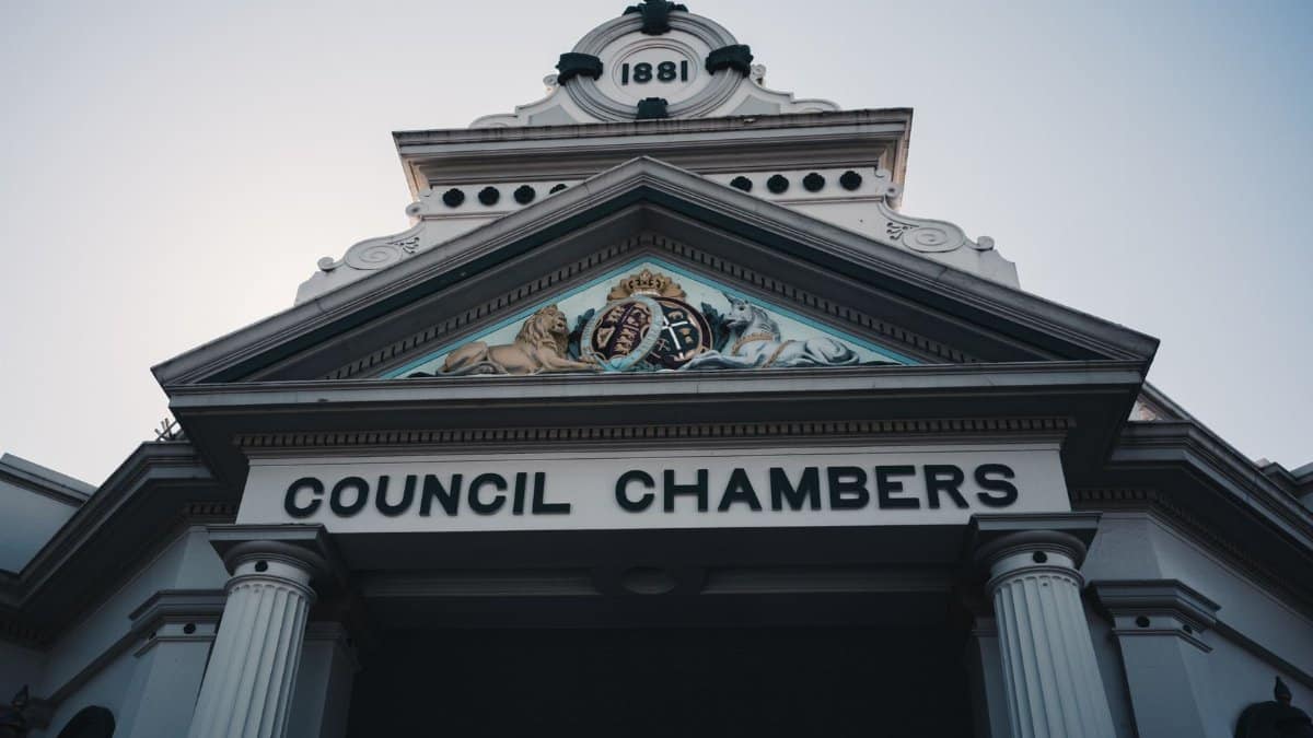 Low angle view of a historic neoclassical council chambers facade with columns and ornate detailing.